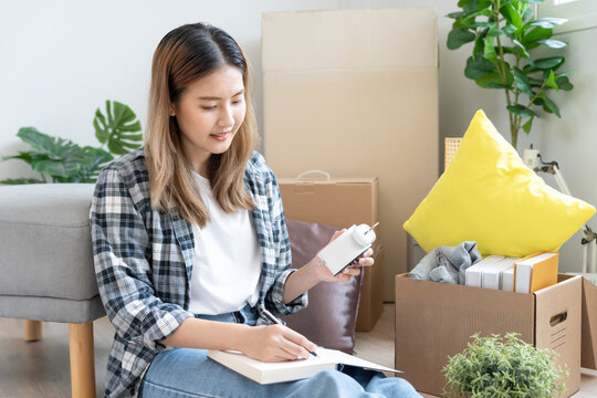Move house, relocation. wife and husband record quantity furniture for new apartment, Inside the room are cardboard boxes containing personal belongings. Move into a house or condominium