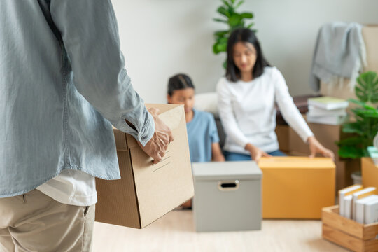 Moving house, relocation. Open the door found couple help setting on new house, inside the room was a cardboard box contain personal belongings and furniture. move in the new apartment or home.