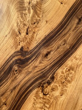 Close up of a polished walnut wood table surface with rich natural grain, knots and live edge detail, showing warm brown tones, symbolizing craftsmanship and quality furniture design.