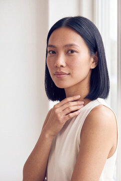 Natural portrait of an asian woman with short bob haircut in soft window light for beauty background and wellness banner