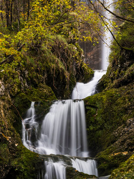 Goriuda waterfall cascades down mossy rocks in the Julian Alps, promoting nature exploration and tourism in a serene, wild forest, Goriuda waterfall, Julian Alps, Chiusaforte, Friuli, Italy.