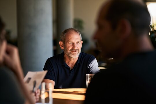 Experienced businessman listening during corporate meeting, discussing business strategy and making decisions with professional team