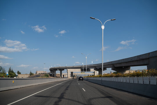 Nairobi, Kenya - 15 May 2022: View of the modern Nairobi Expressway with its elevated concrete overpass, streetlights, and clear blue sky in Nairobi, Kenya.
