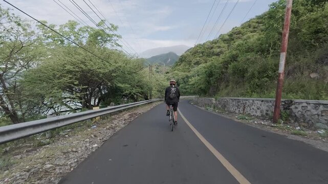 Cyclist Riding on Scenic Mountain Road