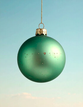 Green Christmas Bauble on Soft Teal Gradient Background