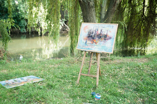 Artist painting easel in the park by the river