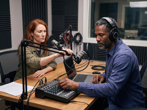 Audio recording session in a studio with two people working on a project