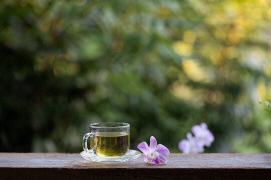 Tea in a glass cup and purple orchid