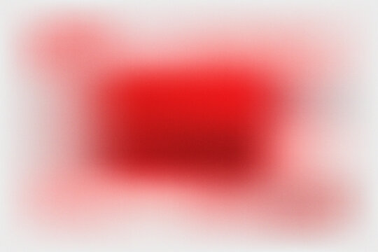 Abstract red spray paint texture with soft grainy gradient and artistic blurred background.