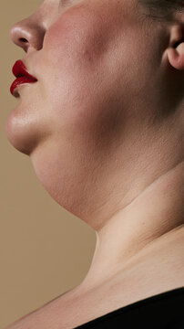 Woman proudly showing her neck and chin, embracing body positivity and self acceptance, celebrating natural beauty with glowing skin and bold red lips