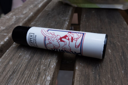 Barcelona, Spain - June 19, 2026: Clipper lighter featuring the cartoon character Asterix resting on a rustic wooden table
