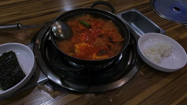 Kimchi jjigae or Korean kimchi spicy soup with rice. Traditional Korean dish made with vegetables, meat, eggs and tofu, served in a hot pot. South Korea