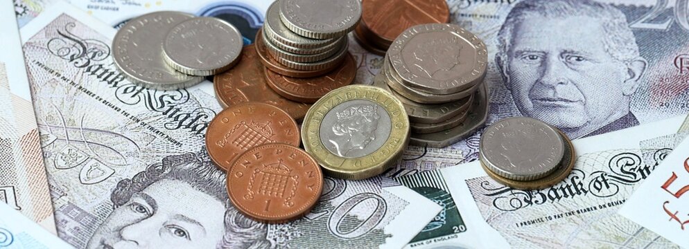 British pound money banknotes and coins on table. United Kingdom cash bills of GBP currency