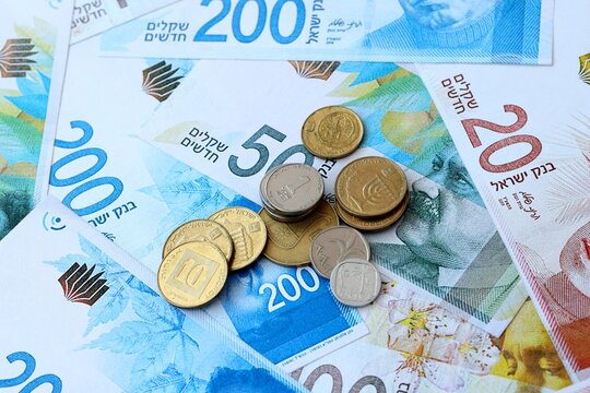 Israeli shekel money banknotes and coins on table. Israel cash bills of ILS currency