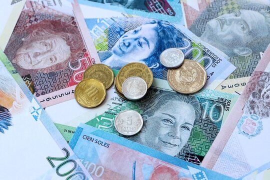 Peruvian sol money banknotes and coins on table. Peru cash bills of PEN currency