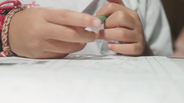 Close-up footage of a mother pointing at a worksheet while helping her child with homework, showing family support, learning, education, and parent-child interaction.