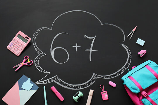 Chalkboard with math problem 6+7 in a thought bubble surrounded by school supplies and stationery, top view, Various school supplies and stationery items are arranged around the chalkboard