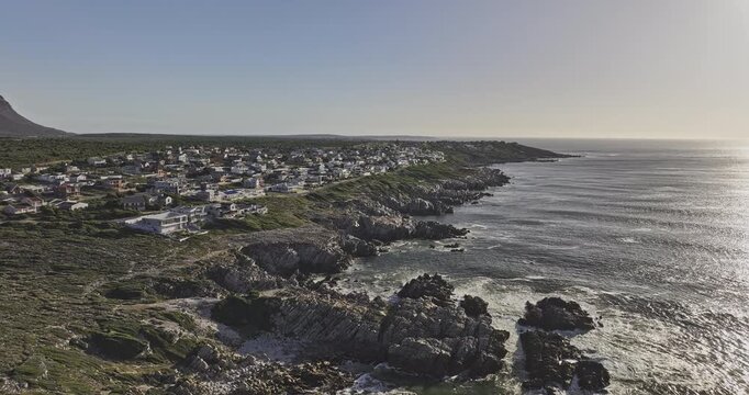 Gansbaai South Africa Aerial v31 sunset flyover above Klipgat Caves and De Kelders shoreline with residences and coastal mountains - Shot with Mavic 3 Pro Cine - Jan 8th 2024