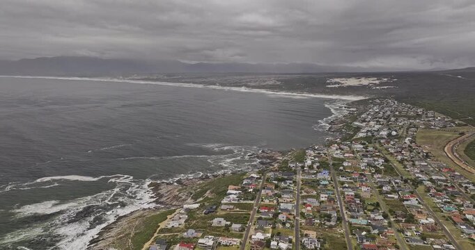 Gansbaai South Africa Aerial v7 flyover along De Kelders shoreline and residences beside Walker Bay Nature Reserve under overcast skies - Shot with Mavic 3 Pro Cine - Jan 7th 2024