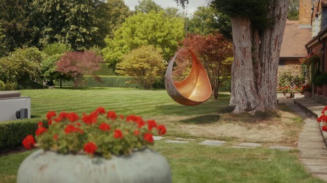 Modern garden features a unique copper swing chair near lush greenery