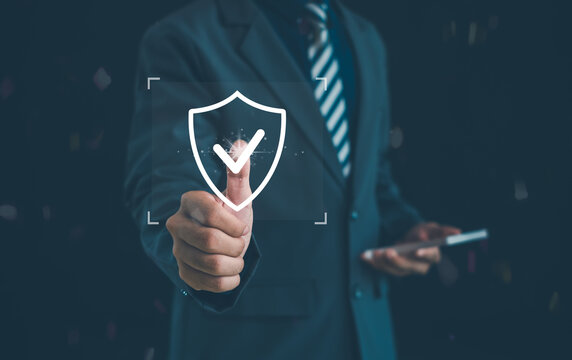 Business professional using a digital shield and check mark, symbolizing security, protection, trust, risk management, cybersecurity, compliance, insurance, and secure digital services.