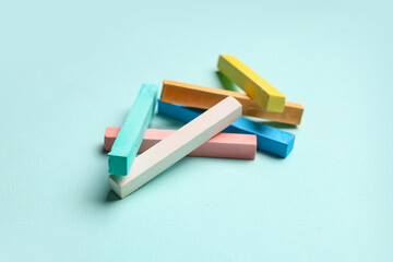 Pieces of colorful chalks on blue background, closeup © Pixel-Shot