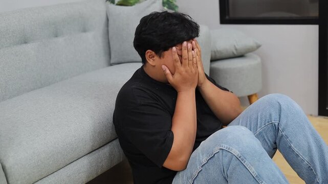 Asian overweight man suffering from depression at home
