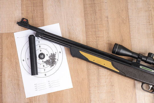 High Angle of Scoped Weapon Barrel with Metal Pellets and Bullseye Target