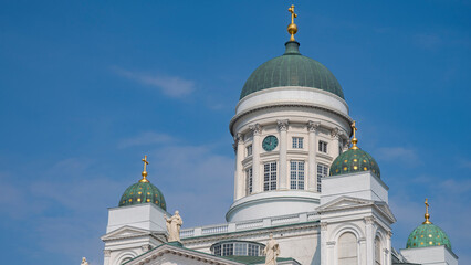 Close up of Helsinki Cathedral green domes with clock and blue sky copy space © Aliaksei