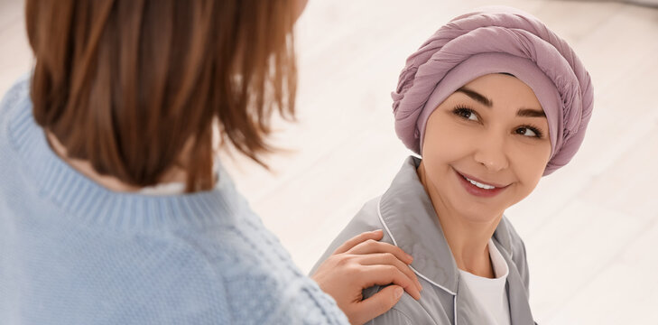 Smiling woman with cancer wearing a headscarf receiving support from a friend healthcare and emotional well-being, this image concepts of hope care and resilience in the of disease
