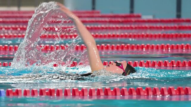 Swimmer girl swims backstroke swimming style in the pool