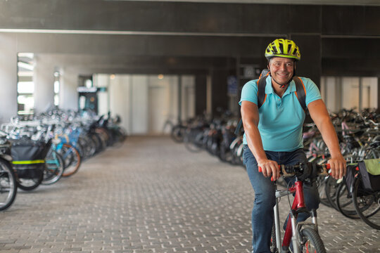 Smiling mature cyclist with helmet and backpack