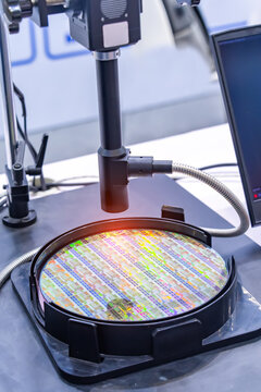 Silicon Wafers with microchips used in electronics for the fabrication of integrated circuits under the microscope,integrated circuits to manufacture CPU and GPU