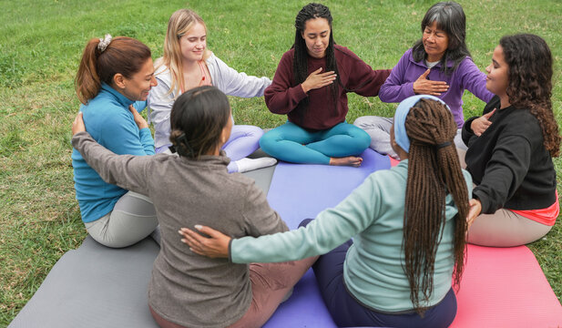 Women's circle during a group yoga class with people of different age and body types - Healthy lifestyle, mindfulness and meditation concept - Main focus on asian woman face