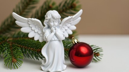 Fototapeta premium Decorative Angel Statue with Christmas Ornament and Evergreen Branch