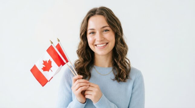 Happy young woman holding small Canadian flags