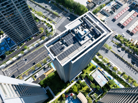 Aerial view of solar panels on a modern skyscraper roof in the city