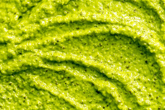 Green yogurt ice cream with pistachios, kiwi and avocado. Fresh fruit smoothie. Ice cream texture. Delicious sweet dessert close-up as background.