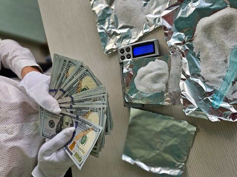 Scene showing money and a scale with a white substance