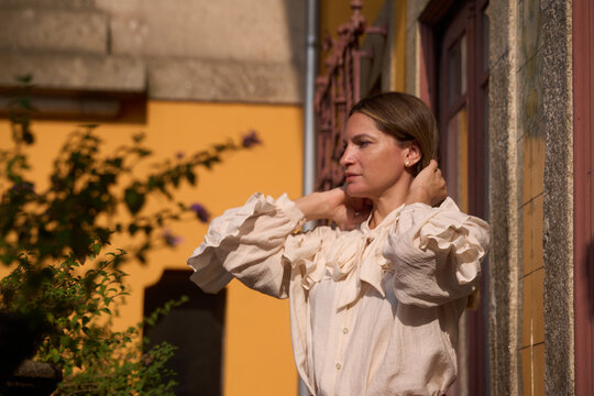 Woman Adjusting Hair in a Park Setting