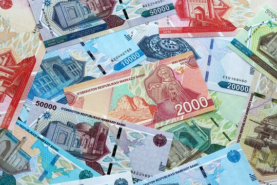 Uzbekistani som money banknotes pile on table. Uzbekistan bills of UZS currency close up
