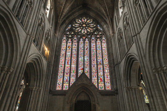 Worcester, England, United Kingdom - 21 July 2026: View of the intricate stained glass window inside Worcester Cathedral, featuring detailed religious figures and stone arches.