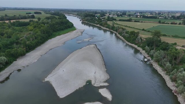 Po River near Isola Serafini, Monticelli d'Ongina, Piacenza, Emilia-Romagna, Italy, revealing exposed gravel bars, braided low-flow channels and reduced discharge during the 2026 heatwave, aerial