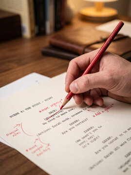Screenwriter Writing Film Screenplay Script Draft with Pencil on Desk