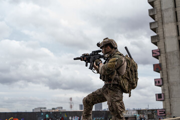 Fototapeta premium Special operation force soldier holding assault rifle weapon on rooftop during tactical urban combat mission in city
