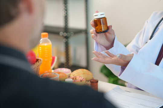 Nutrition consultant showing pill bottle to patient during dietary health consultation