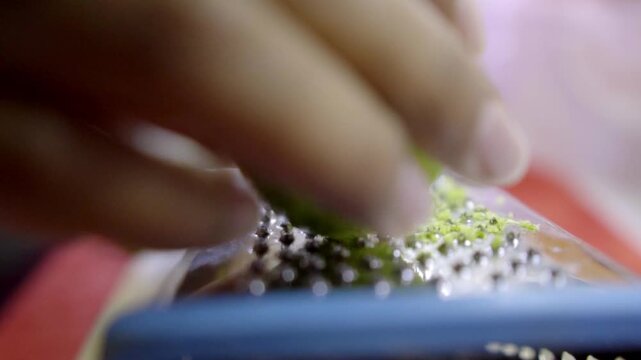 Close up of a hand grating fresh lime on a metal grater featuring citrus zest fine shavings and food preparation for cooking or baking