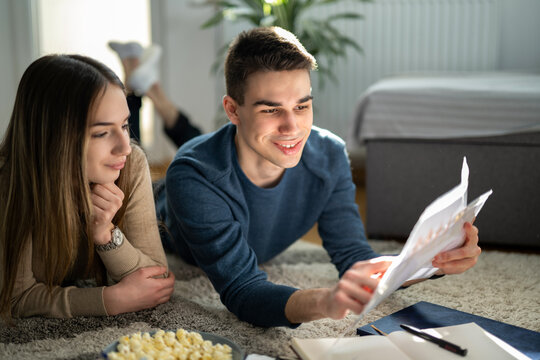 Students reviewing academic paper together at home