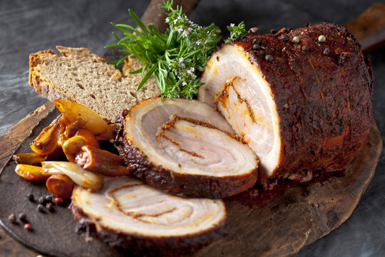 Sliced rolled roast pork with braised vegetable on a wooden board