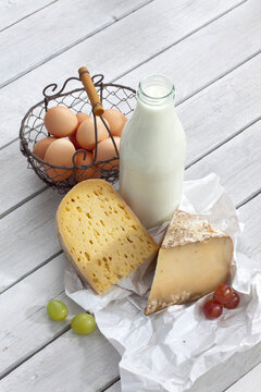 Cheese, eggs and milk on wooden table